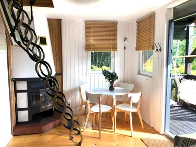a small dining room with a table and chairs at Domek Pod Lasem in Trzciana