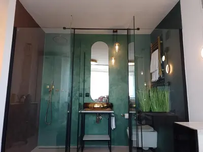 a bathroom with a sink and a glass shower at Alexa d'Oro Rooms in Kraków