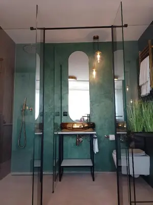 a bathroom with a sink and a glass shower at Alexa d'Oro Rooms in Kraków