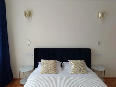 a bedroom with a large bed with two pillows at Alexa d'Oro Rooms in Kraków