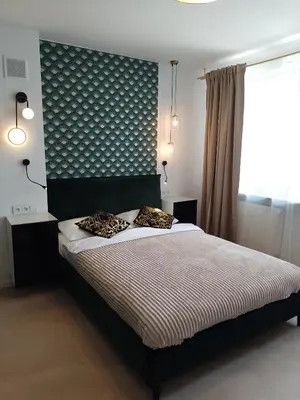 a bedroom with a bed with a black headboard at Alexa d'Oro Rooms in Kraków