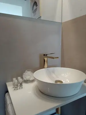 a white sink sitting on top of a bathroom counter at Alexa d'Oro Rooms in Kraków