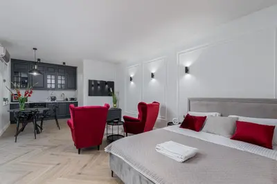 a bedroom with a large bed and red chairs at Apartament w centrum Krakowa 109 in Kraków