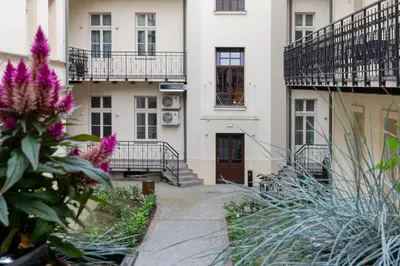 a courtyard of a building with purple flowers at Apartament w centrum Krakowa 109 in Kraków