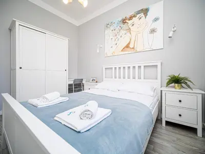 a white bedroom with a bed with towels on it at BARBICAN BY LANDMARK APARTMENTS in Kraków