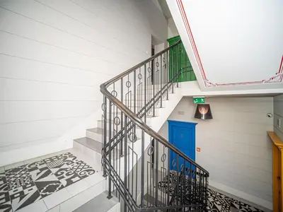 a staircase with a blue door in a house at BARBICAN BY LANDMARK APARTMENTS in Kraków