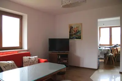 a living room with a red couch and a tv at Dom na Książkowej in Jordanów