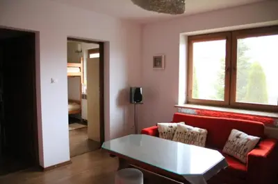 a living room with a red couch and a table at Dom na Książkowej in Jordanów