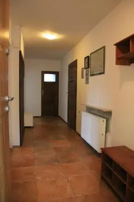 a room with a hallway with two doors and a tile floor at Dom na Książkowej in Jordanów