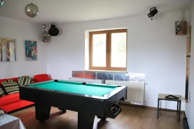 a living room with a pool table in it at Dom na Książkowej in Jordanów