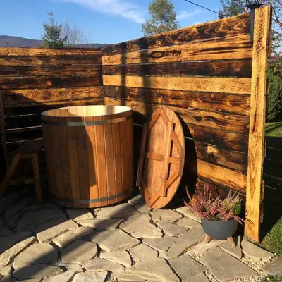 a wooden barrel next to a wooden fence at Agroturystyka Zagroda Miłkowskie in Słopnice