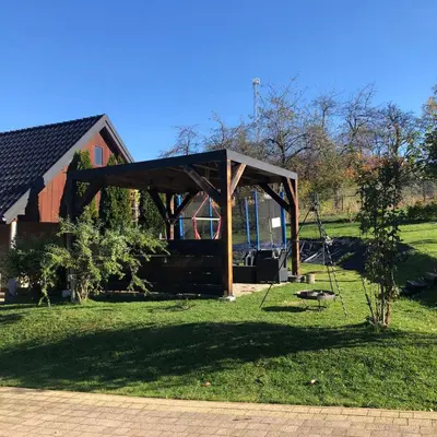 a pavilion in a field next to a barn at Agroturystyka Zagroda Miłkowskie in Słopnice