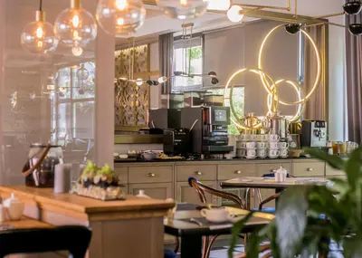 a kitchen with a table and chairs in a room at Hotel Apis in Kraków