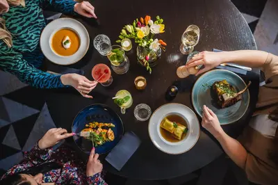 a group of people sitting around a table eating food at Hotel Apis in Kraków