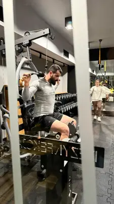 a man sitting on a bench in a gym at Hotel Apis in Kraków