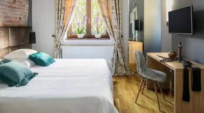 a bedroom with a bed and a desk and a window at Cracowdays in Kraków