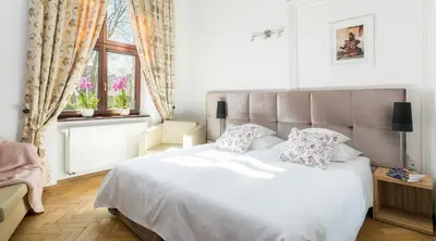 a bedroom with a white bed and a window at Cracowdays in Kraków