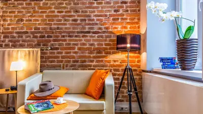 a living room with a couch and a brick wall at Cracowdays in Kraków
