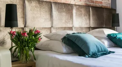 a bed with white pillows and a vase of flowers on it at Cracowdays in Kraków