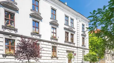 a white building with windows on a street at Cracowdays in Kraków