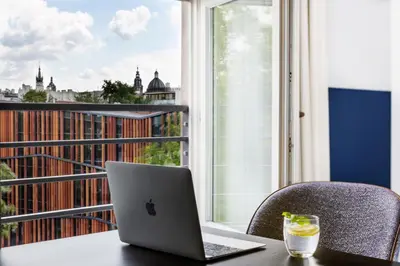 a laptop sitting on a table in front of a window at H11 Aparthotel in Kraków