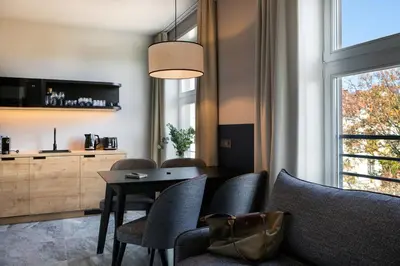 a dining room with a table and chairs and a window at H11 Aparthotel in Kraków