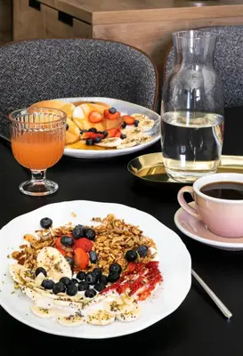 a table with two plates of food and a drink at H11 Aparthotel in Kraków