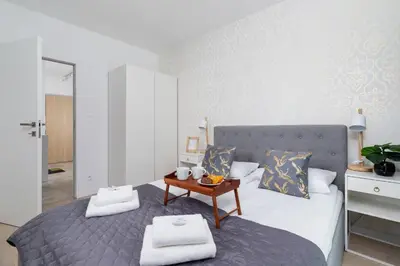 a bedroom with a bed with a table on it at Apartment with Balcony & Parking Mogilska by Renters Prestige in Kraków