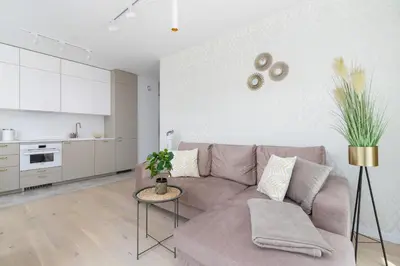 a living room with a couch and a kitchen at Apartment with Balcony & Parking Mogilska by Renters Prestige in Kraków