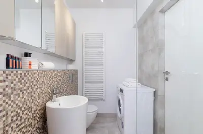 a bathroom with a white toilet and a sink at Apartment with Balcony & Parking Mogilska by Renters Prestige in Kraków