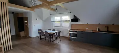 a kitchen with a table and chairs in a room at Apartament Wierchy in Klikuszowa