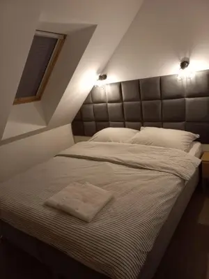 a bedroom with a large bed with two lights on it at Apartament Wierchy in Klikuszowa