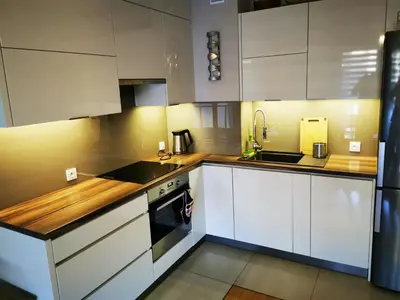a kitchen with white cabinets and a sink and a stove at Apartament Kraków Arena 20B in Kraków