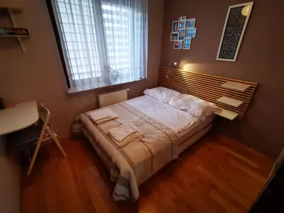 a small bedroom with a bed with a window at Apartament Kraków Arena 20B in Kraków