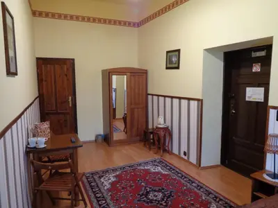 a living room with a table and a door and a rug at Globtroter Guest House in Kraków