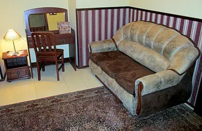 a couch in a living room with a table and a desk at Globtroter Guest House in Kraków