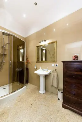 a bathroom with a sink and a shower and a mirror at Apartamenty Gołębia 3 in Kraków