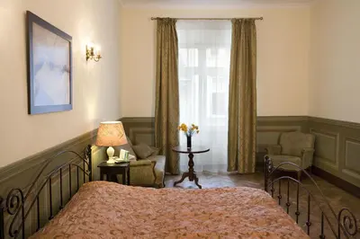 a bedroom with a bed and a chair and a window at Apartamenty Gołębia 3 in Kraków