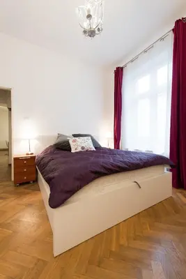 a bedroom with a bed with purple sheets and a window at Apartamenty Gołębia 3 in Kraków