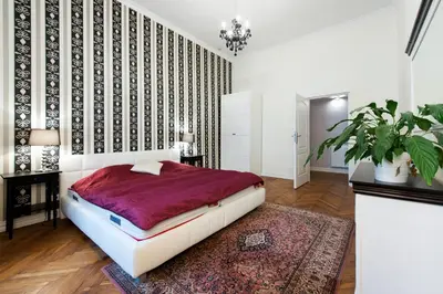 a bedroom with a large bed and a rug at Apartamenty Gołębia 3 in Kraków