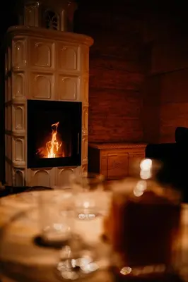 a table in front of a fire in a fireplace at Babiogórska Chata - dom z bali z jacuzzi i sauną in Zawoja