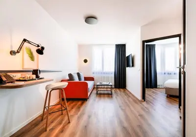 a living room with a red couch and a table at Hotel Convictus Cracovia for business & travellers in Kraków
