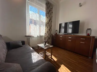 a living room with a couch and a flat screen tv at P&J Apartments Floriańska in Kraków