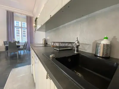 a kitchen with a black sink and a table at P&J Apartments Floriańska in Kraków