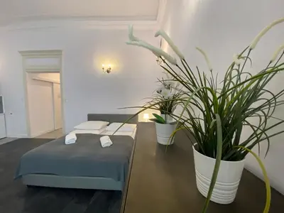 a room with a bed and potted plants on a table at P&J Apartments Floriańska in Kraków
