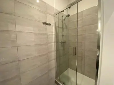 a shower with a glass door in a bathroom at P&J Apartments Floriańska in Kraków