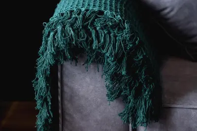 a green scarf on the side of a couch at Solaris Park Apartment Tauron Arena by Renters Prestige in Kraków