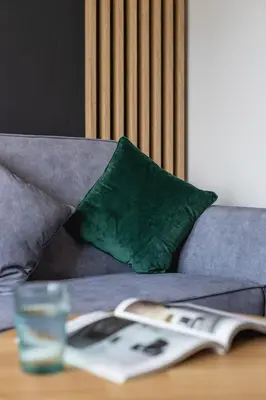 a table with a book and a glass on a couch at Solaris Park Apartment Tauron Arena by Renters Prestige in Kraków