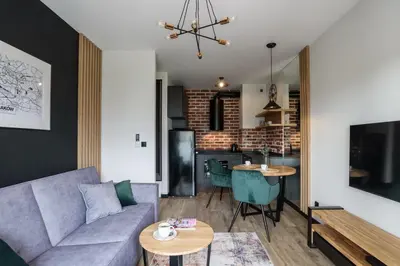 a living room with a couch and a table at Solaris Park Apartment Tauron Arena by Renters Prestige in Kraków