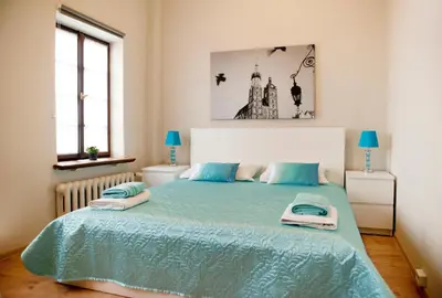 a bedroom with a large bed with blue sheets at Dom Casimi in Kraków